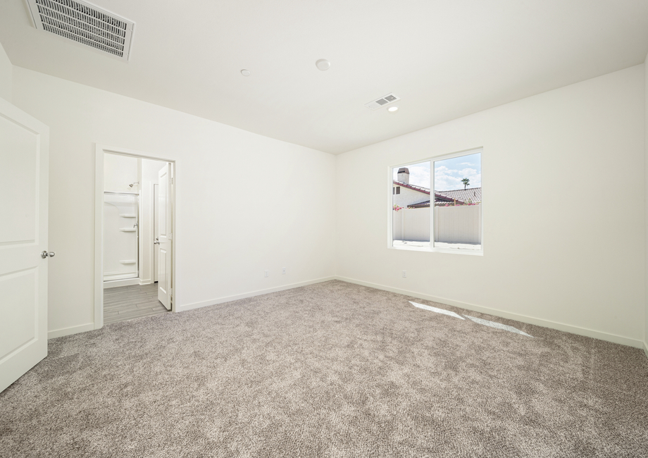 The master suite has carpet and a large window.