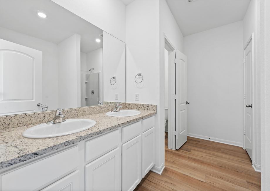 The master bathroom has a long vanity with two sinks and plenty of storage