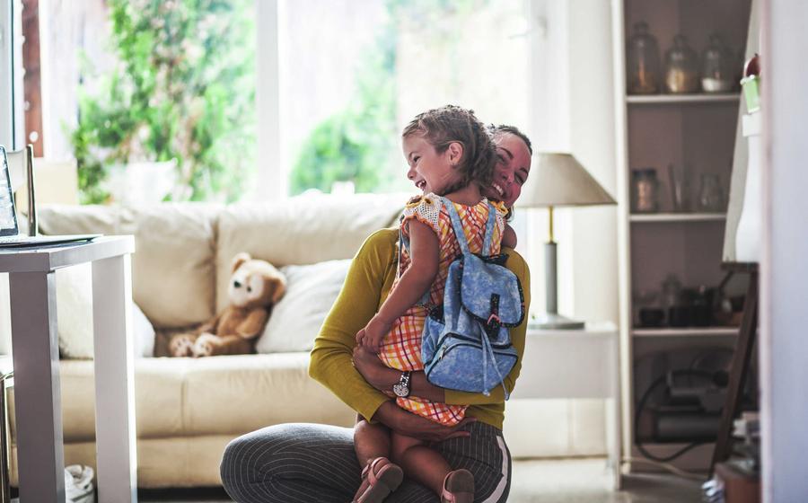 A mother hugging her daughter in their brand-new home.