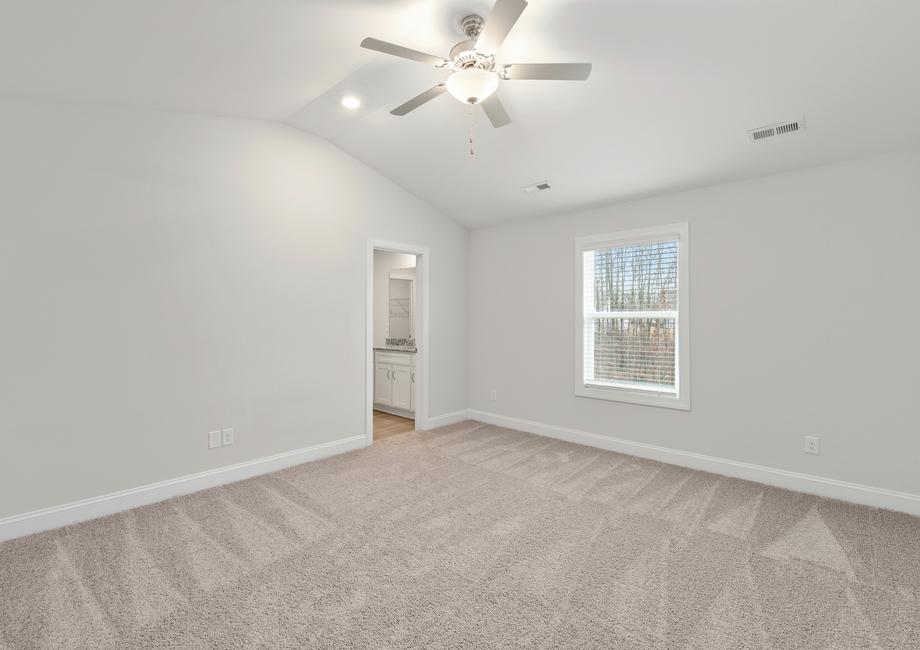 Master bedroom with carpet, windows and a fan.