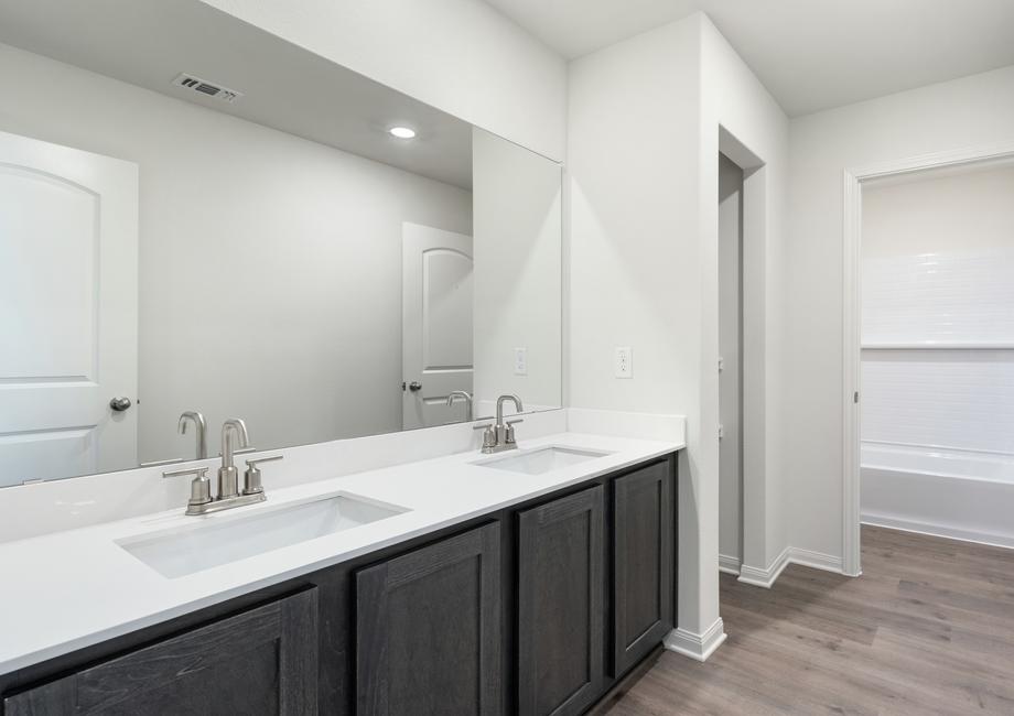 The secondary bathroom has a large vanity space and shower tub combo.