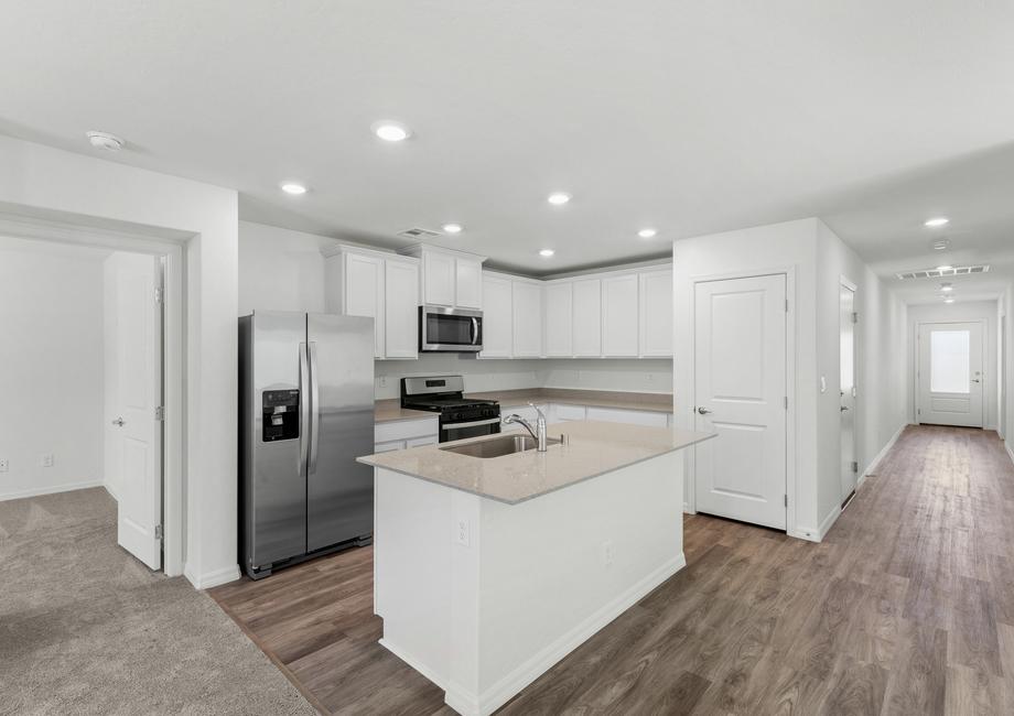 The chef-ready kitchen has stainless steel appliances and plank flooring.