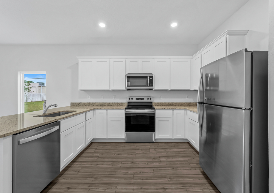 Stainless steel appliances fill the kitchen