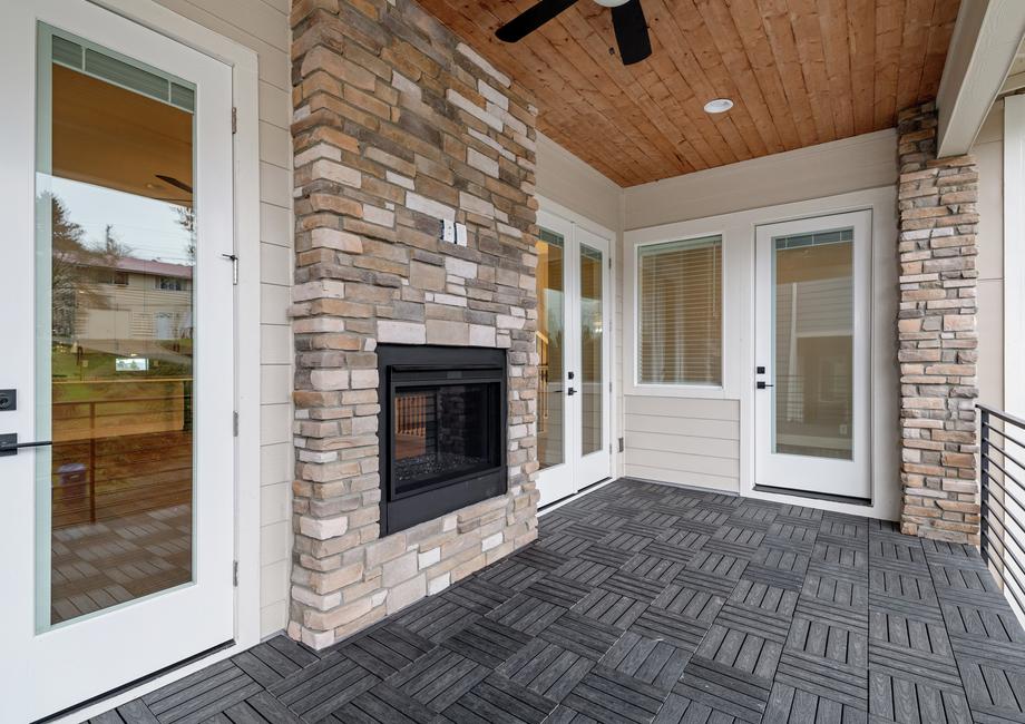 Covered outdoor living area with a fireplace.