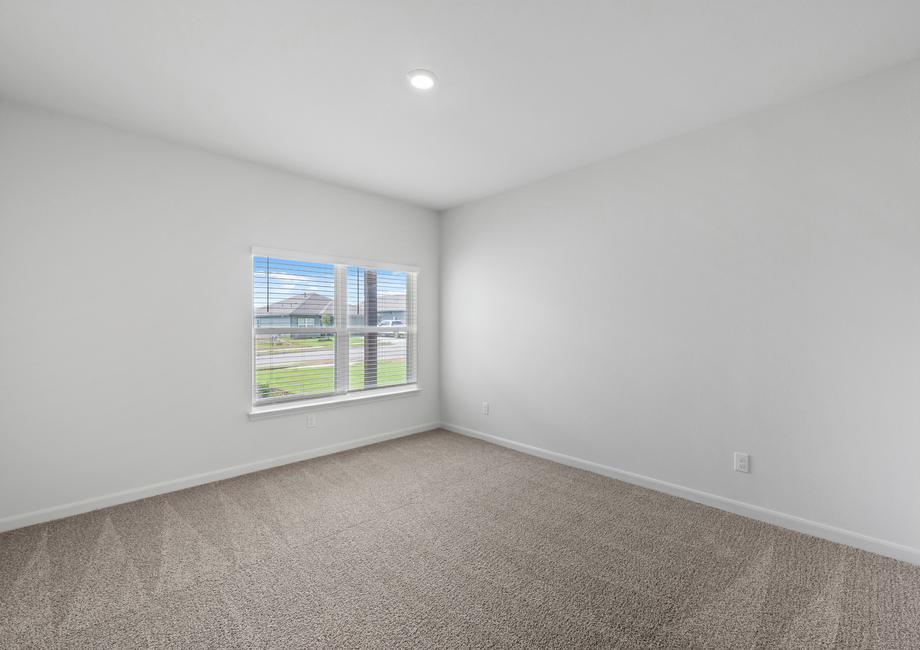 The spacious master bedroom has a large window that lets in natural light and backyard views.