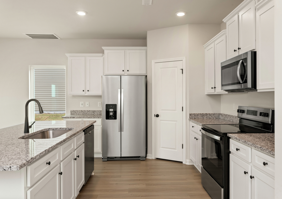 This kitchen has wood cabinets and granite countertops