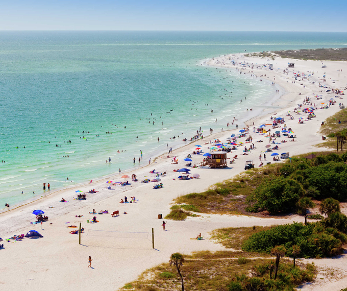 Sarasota, Florida Lido Beach, Siesta Key during a busy summer day with beachgoers, sunbrellas, and blue waters