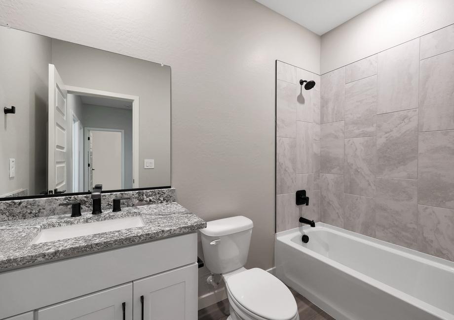 Secondary bathroom with a tiled-lined dual shower and tub.