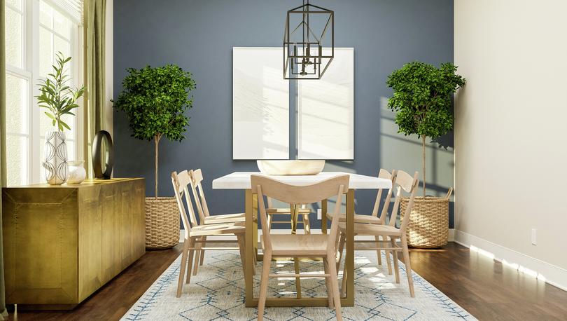 Rendering of a dining room showing a
  large gold media cabinet on the left and a large dining table with chairs
  centered under a metal light fixture in front of a blue accent wall with dark
  wood look flooring throughout.