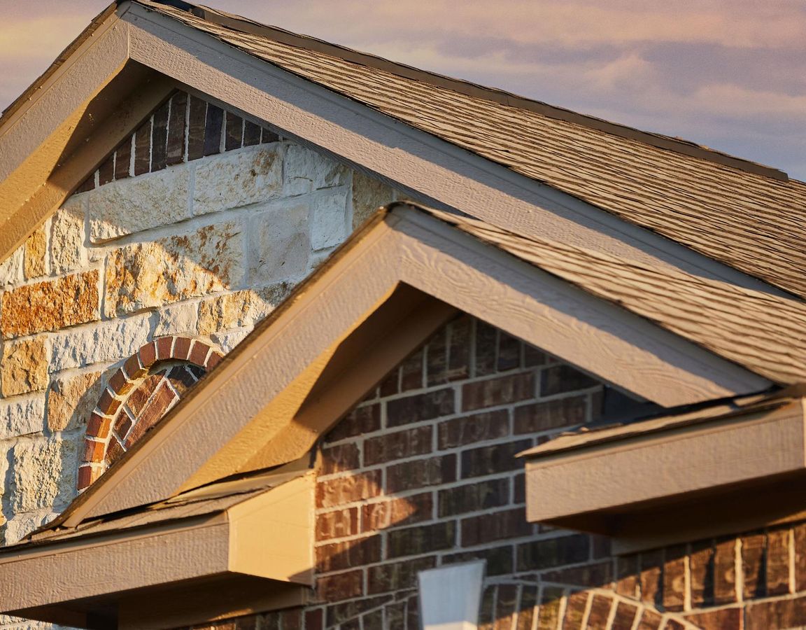 Detailed shot of the peaks of a home with brick and stone.