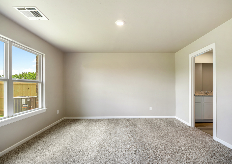 The master bedroom is filled with lighting from a beautiful large window.