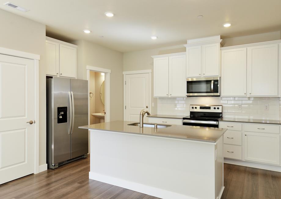 The kitchen has stainless steel appliances and plank flooring.