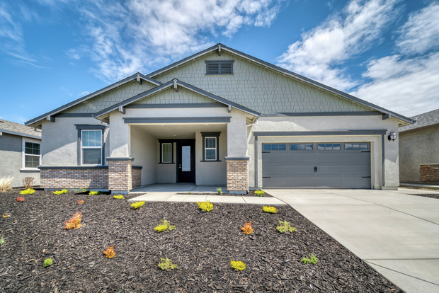 Exterior of the Marshall with a two-car garage, covered front porch, and professional front landscaping.