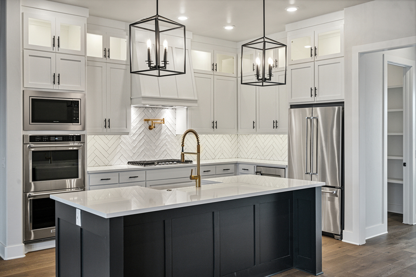The kitchen of the Texoma has white wood cabinetry and a tile backsplash.
