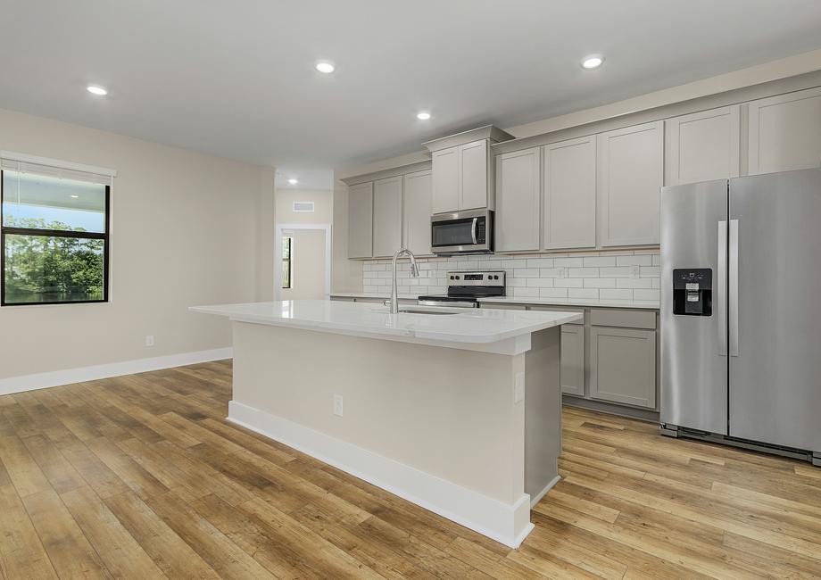 Stunning kitchen with gray cabinetry, subway tile backsplash and Whirlpool brand appliances.