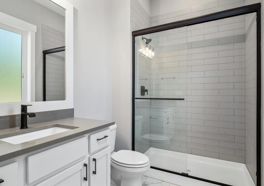 One of the secondary bathrooms includes a shower with a sliding glass door.