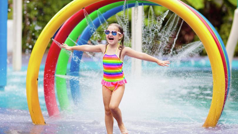 Girl playing on a colorful splash pad.