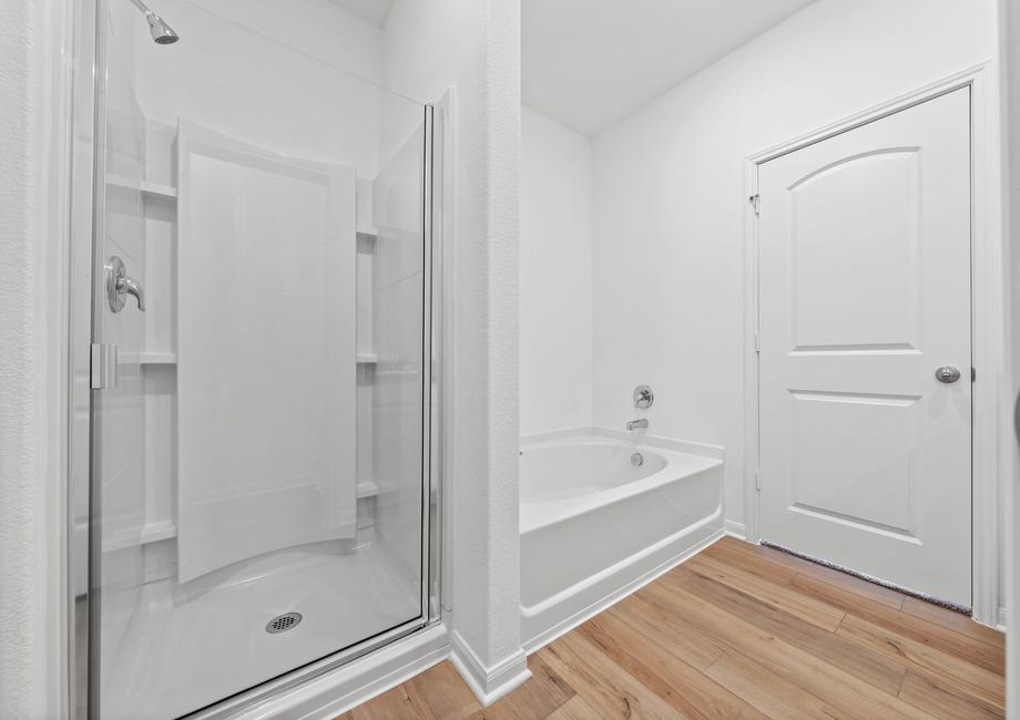 The master bathroom features a step-in shower and soaker tub