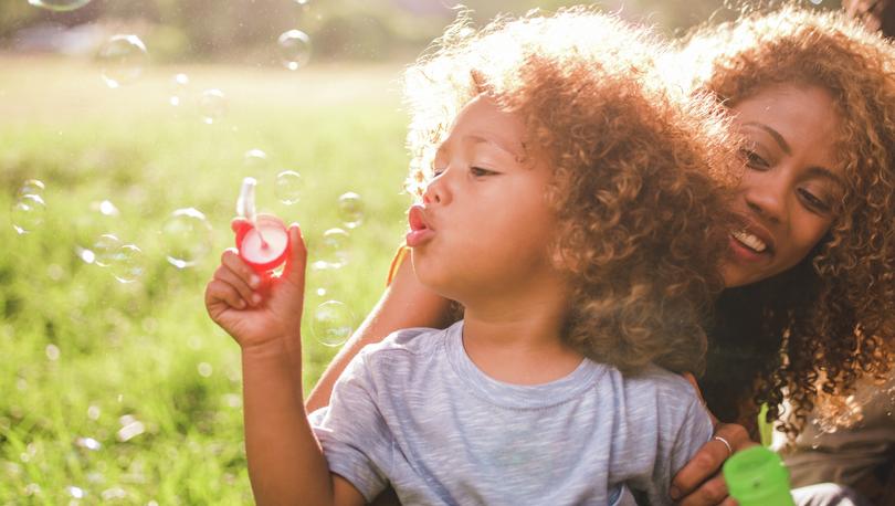 Mom and daughter blowing bubbles.