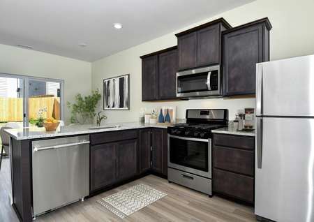 The kitchen has beautiful granite countertops and brown cabinets.