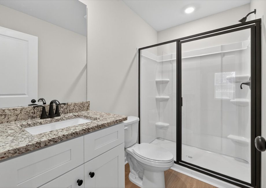 The master has a glass-enclosed shower. 