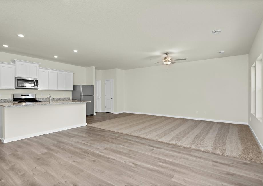 The family room is spacious and has a ceiling fan.