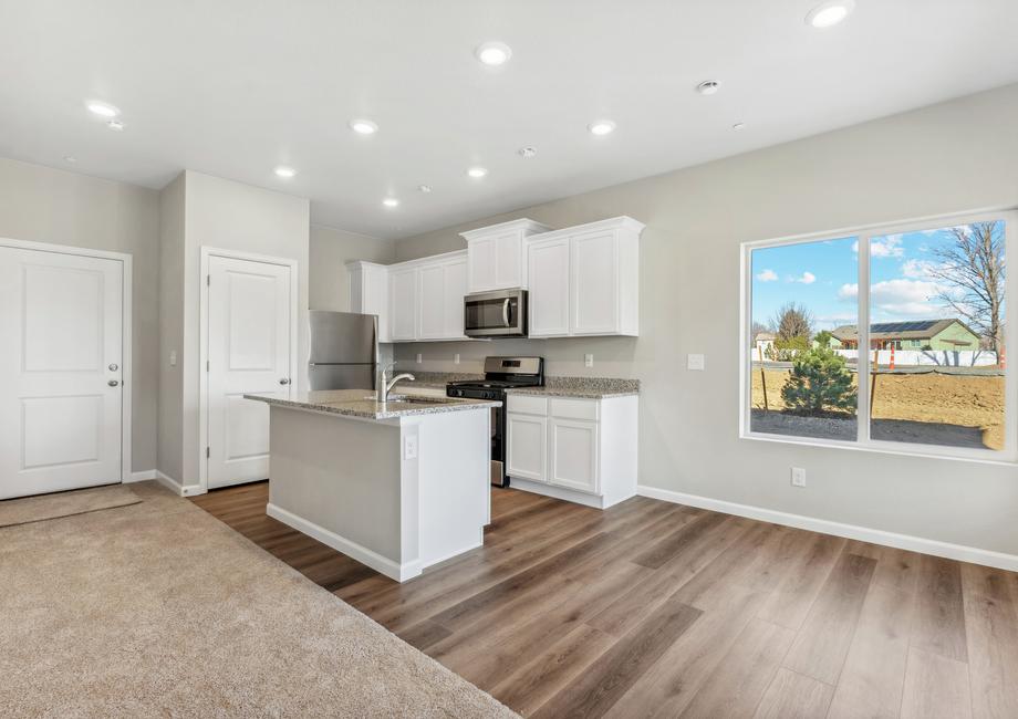 The kitchen has stainless steel appliances and plank flooring.