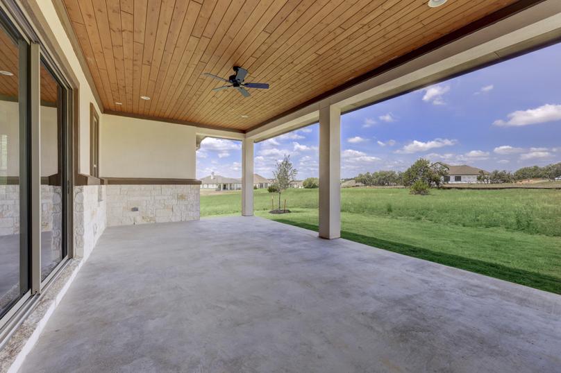 Expansive covered back patio with a ceiling fan, overlooking the stunning scenery that Esperanza has to offer.