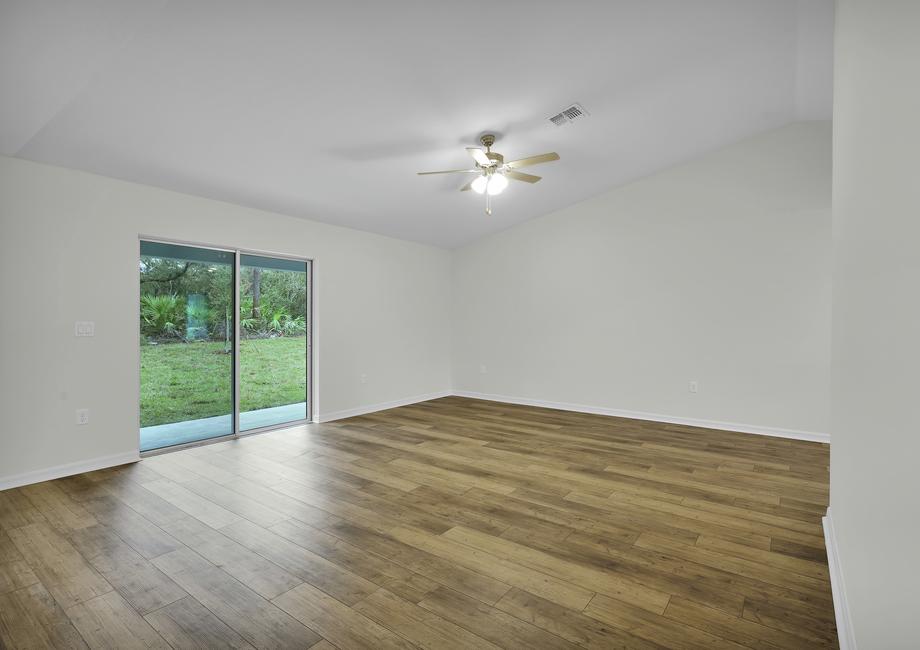 The family room of the Brickell has a sliding glass door that leads out into the backyard