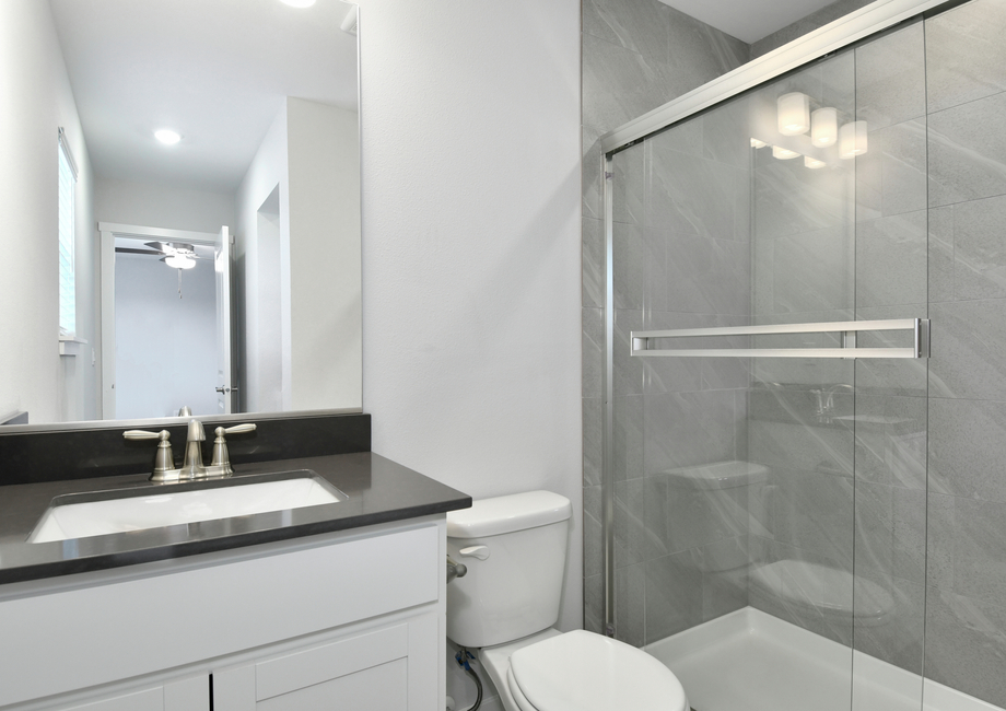 The master bathroom has a step in shower and large vanity.