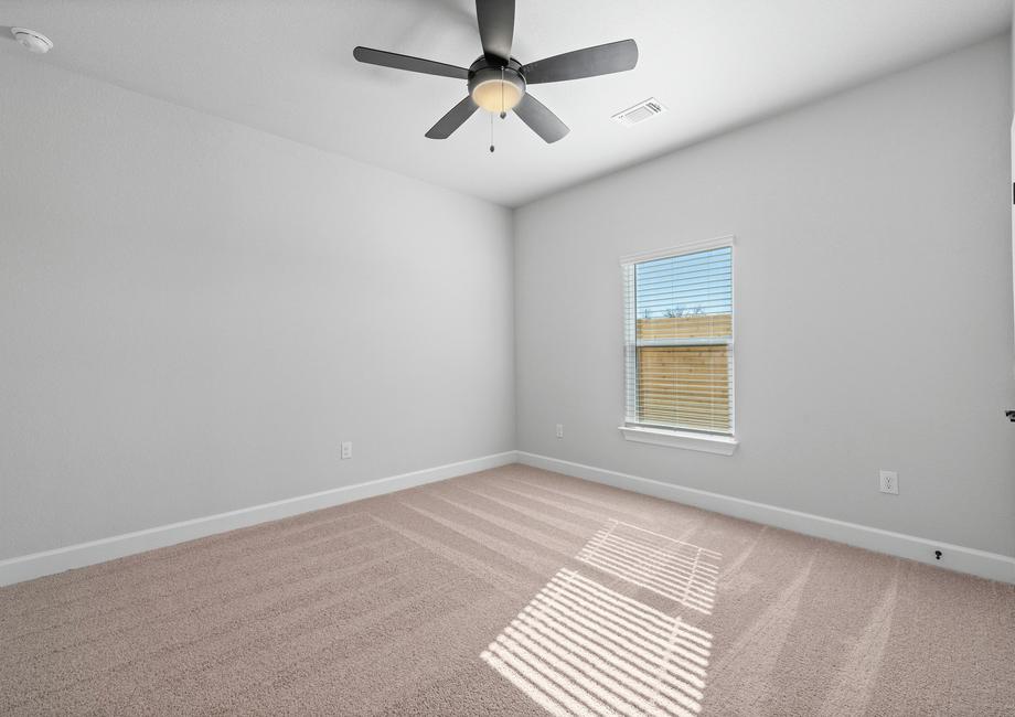 Spacious secondary bedroom including plush carpet, a large window, and double doors to the closet.