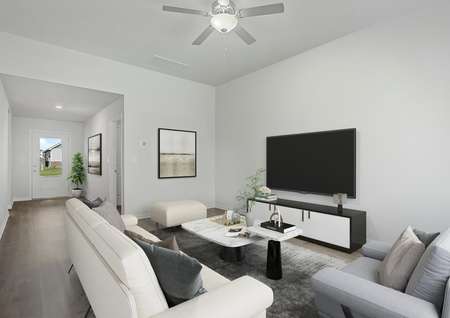 The spacious family room has a ceiling fan and plank flooring.