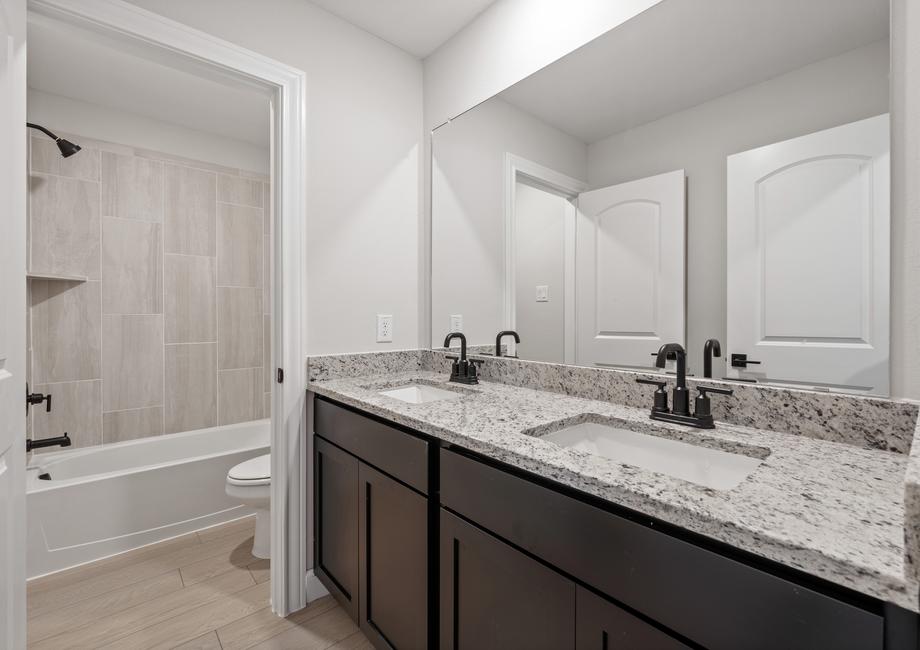 The secondary bathroom has dual sinks and a seperate room for the shower-tub combo and toilet.