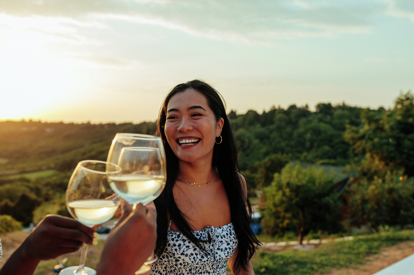<p>Woman enjoying a glass of wine at a winery.</p>