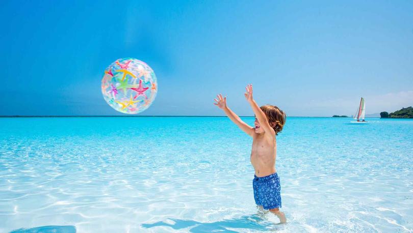 Little boy playing with a ball in the Crystal Lagoon