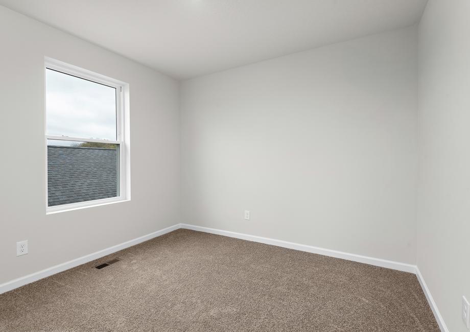 The secondary bedroom has carpet and a nice window.