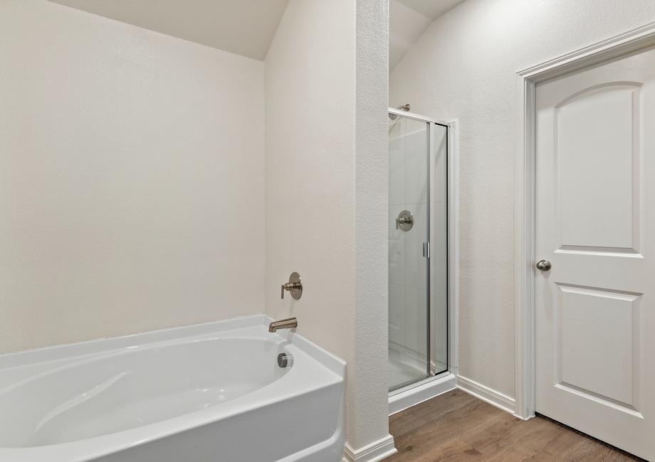 The master bathroom has a large glass, walk-in shower and garden tub.