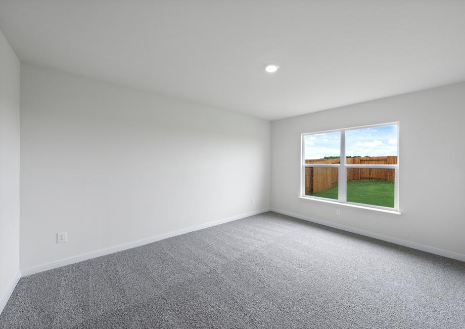 The spacious master bedroom has a large window that lets in natural light and backyard views.