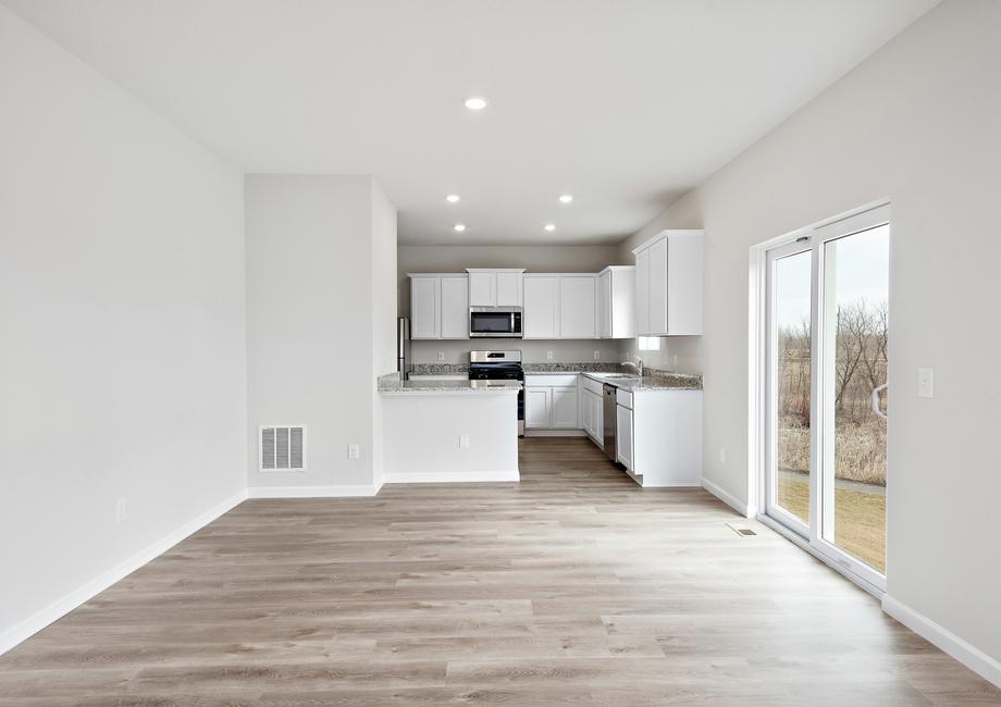 The kitchen is open to the dining room with plank flooring.