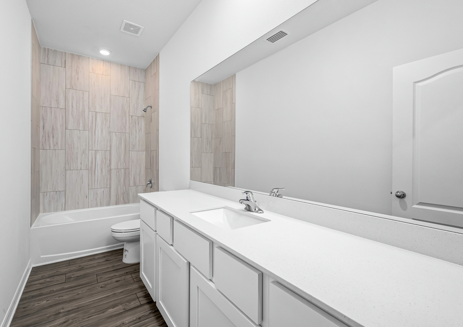 Secondary bathroom with a large vanity and tile detail