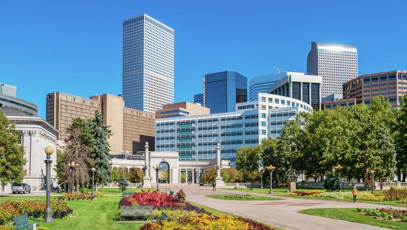 Denver, Colorado Civic Center Park downtown with lush gardens that have blooming yellow, red, and maroon color flowers, walking paths, and green trees