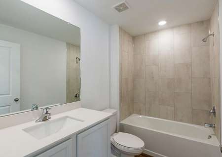 The guest bathroom has a beautifully tiled bathtub