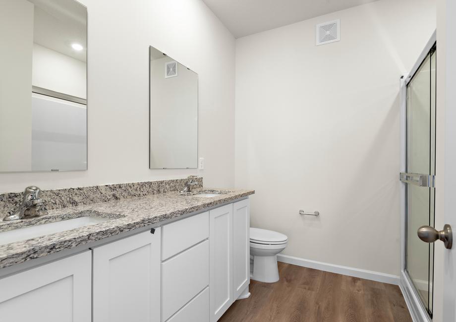 The master bathroom has a dual sink vanity and a step in shower.