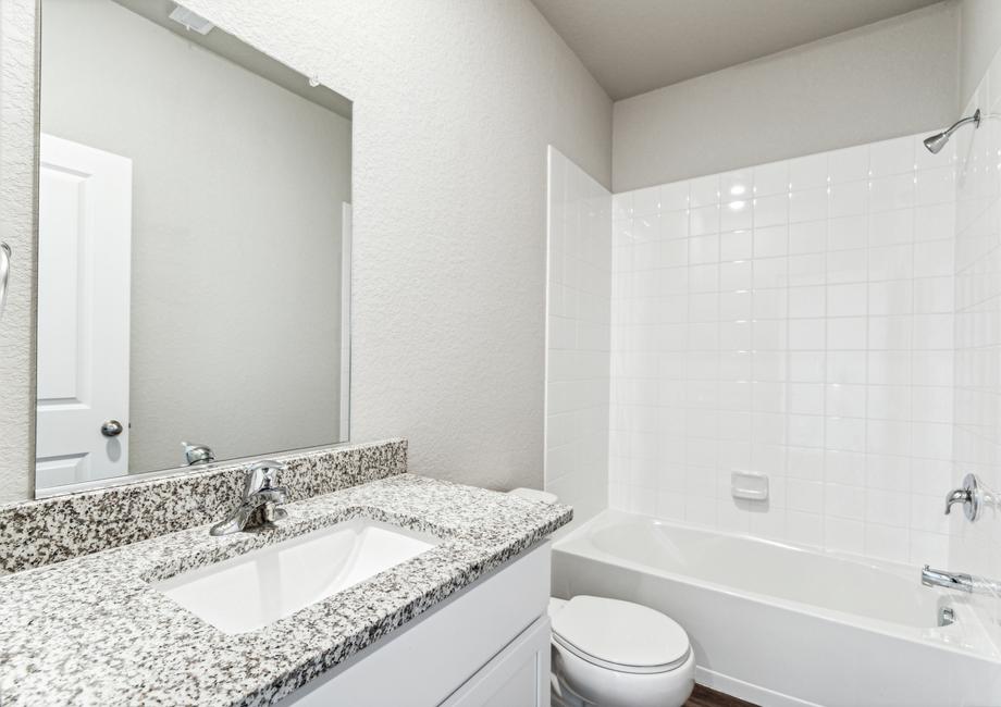 The secondary bathroom has a large vanity and a tub/shower combo.