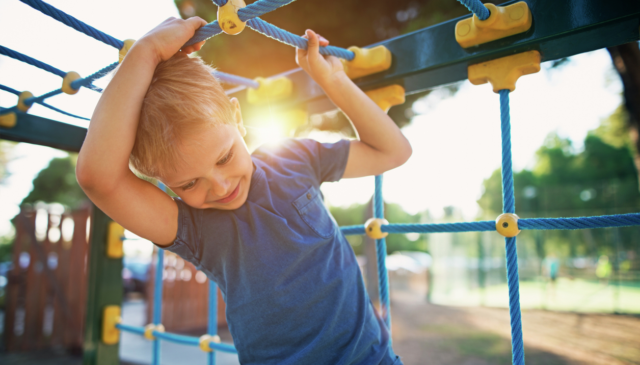 Little boy playing on playground.