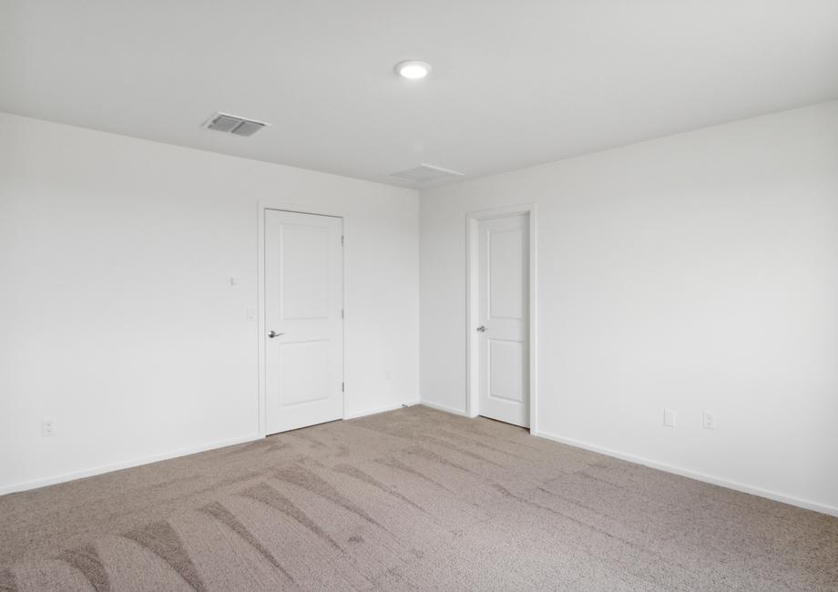 Spacious master bedroom with large windows, allowing for a bright, open room.