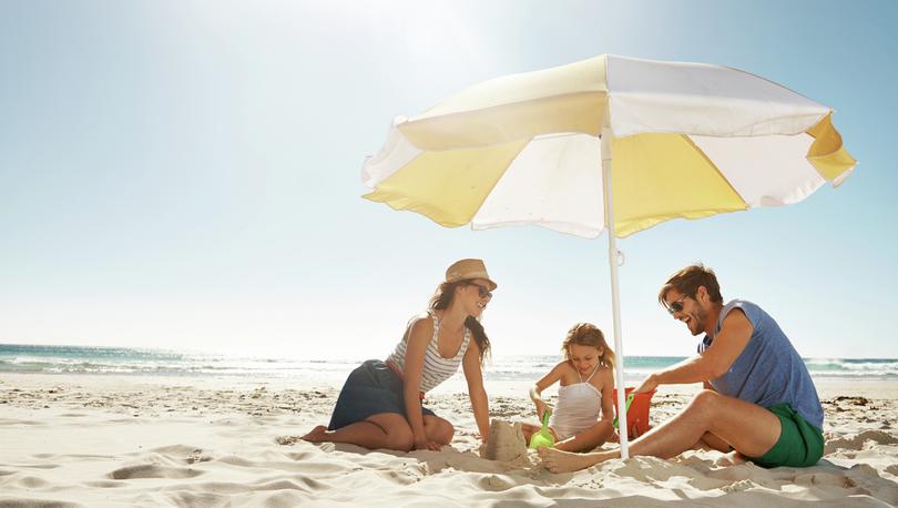 Family enjoying their time together at the beach while playing in the sand. 