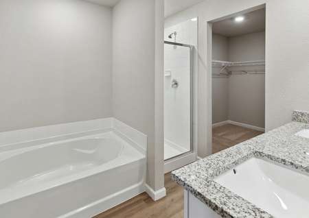 The master bathroom of the Yale floor plan has a large garden tub, glass shower, and large vanity space.