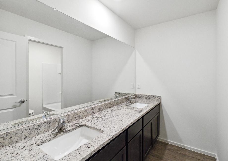 Extra bathroom with a double-sink vanity provides more space for getting ready in the mornings.