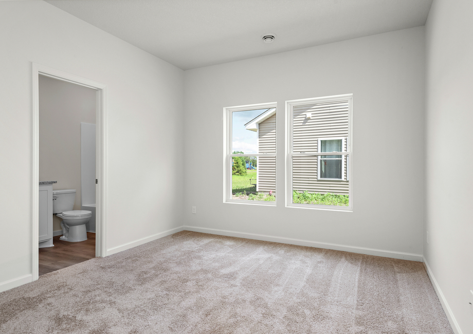 The master bedroom has carpet and a large window.